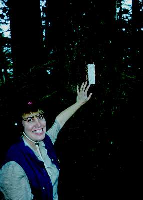 Lisa pointing to a trail marker